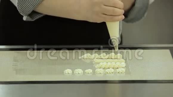 面包师做糖霜漩涡用烹饪管道包在托盘上旋转视频的预览图