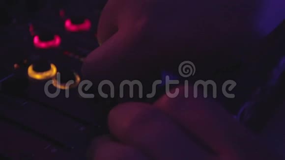 DJ双手按下音频调音台上的按钮夜总会表演音乐视频的预览图