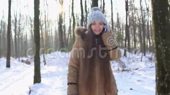 在白雪皑皑的树林里留着长发的小女孩在打电话视频的预览图