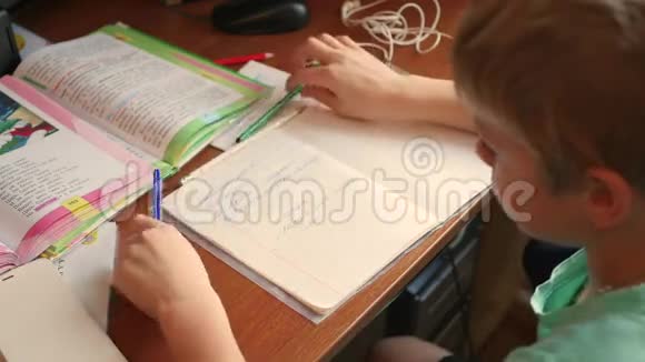 孩子做家庭作业在桌上写一本书视频的预览图