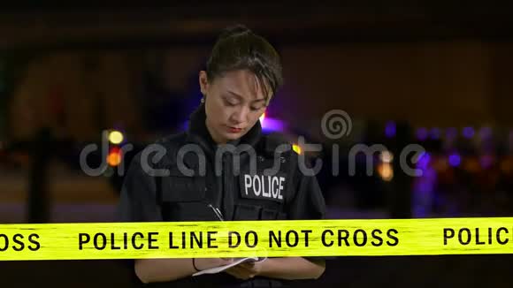 亚裔美国女警察做笔记和使用警察电台视频的预览图