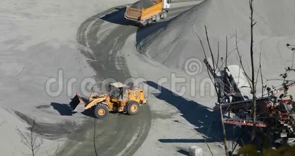 推土机在一个采石场工作推土机在一辆自卸卡车的后面装石头视频的预览图