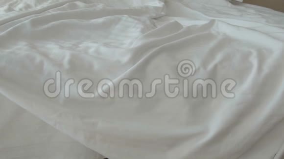 一个年轻的女人脱下睡衣把她扔到床上视频的预览图
