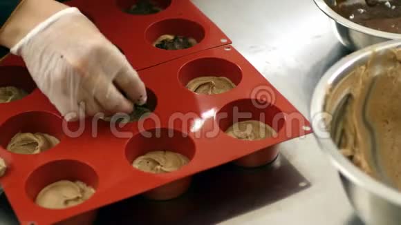 用巧克力片填充硅饼模具的糖果师的录像视频的预览图
