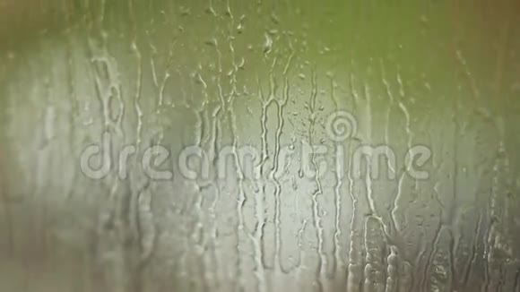 雨滴在雨天的玻璃窗上流动视频的预览图