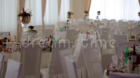 婚礼大厅的内部装饰为客人准备新婚夫妇的餐桌既漂亮又装饰时尚视频的预览图