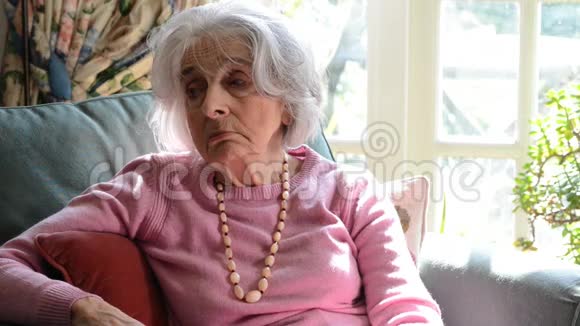 孤独的老年妇女坐在家里的扶手椅上视频的预览图