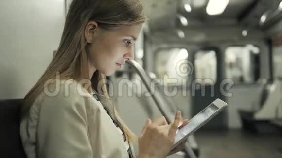 年轻女子在火车上用平板电脑听音乐学生女孩在地铁货车上课后用笔记本电脑视频的预览图