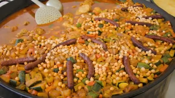 在炒锅里放有香肠西葫芦土豆和胡萝卜的鹰嘴豆视频的预览图