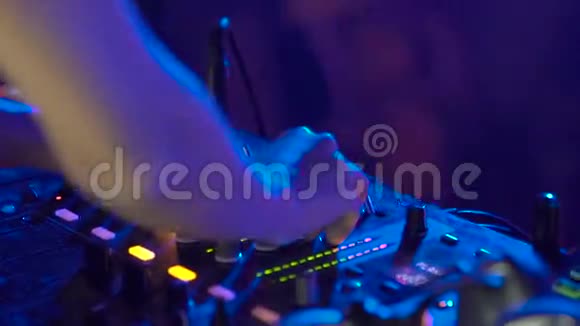 DJ手在DJ甲板上调整各种轨道控制装置视频的预览图