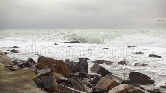 波浪背景上美丽的石头慢潮视频的预览图