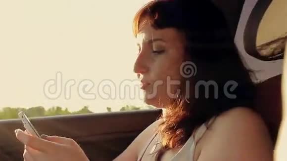 年轻漂亮的女人开车时用手机视频的预览图