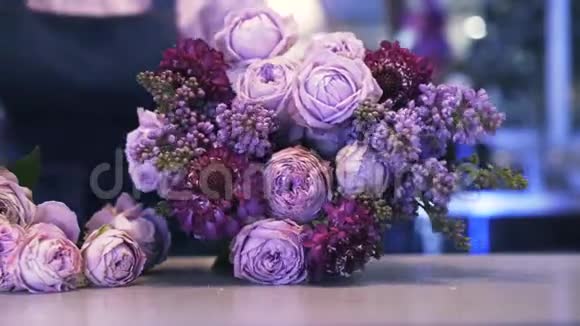 靠近一个做紫色花束的女花店平底锅视频的预览图