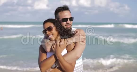 拥抱海岸线上的不同夫妇视频的预览图