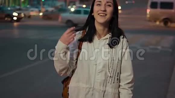 幸福的女人在街上摆姿势在模糊的城市红绿灯前夜晚复古的色彩色调视频的预览图