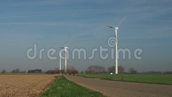 三台旋转风能涡轮机和步行者视频的预览图