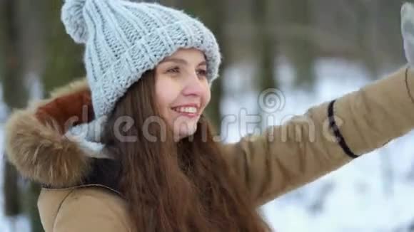在白雪皑皑的树林里一个年轻漂亮的女孩带着礼物她微笑着展示礼物视频的预览图