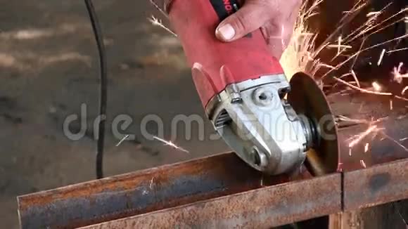 一个男人用一个圆形涡轮机切下一根生锈的金属梁角磨机槽动成品声音视频的预览图