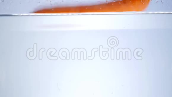 水里的胡萝卜溅在白色的背景上视频的预览图