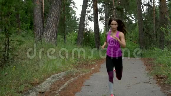 户外运动运动女人穿过树林慢动作视频的预览图
