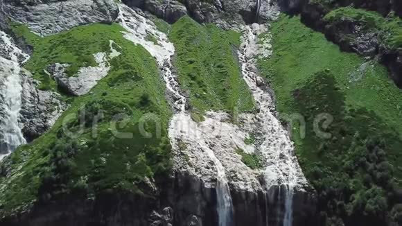 晴天从高山流下来的瀑布从河中流过的山的俯视图视频的预览图
