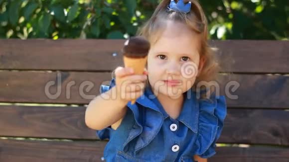 小女孩在阳光明媚的夏天在公园里吃冰淇淋和巧克力婴儿特写肖像视频的预览图