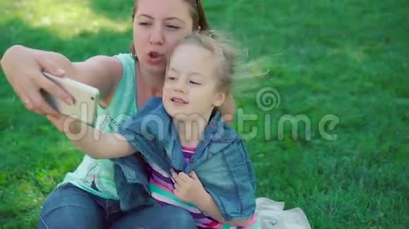 小女孩和妈妈在公园里休息自拍视频的预览图