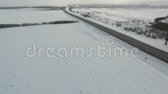 在雪域驾驶冬季道路的卡车和汽车的空中射击视频的预览图
