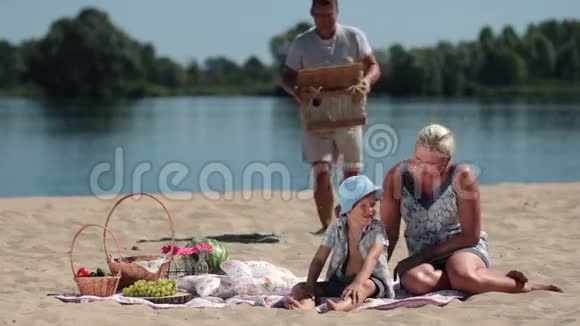 快乐的一家人在海滩上野餐视频的预览图
