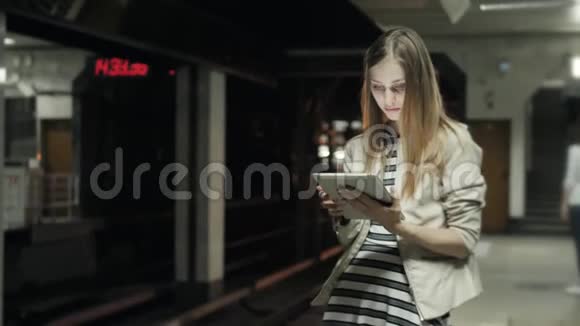 年轻女子在火车上用平板电脑听音乐学生女孩在地铁货车上课后用笔记本电脑视频的预览图