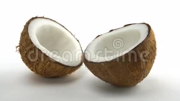 成熟的热带椰子分成两半在白色背景上旋转异国的水果罗贝视频的预览图
