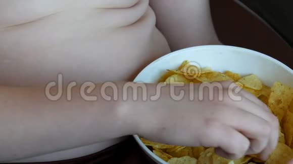 厚男孩吃薯片孩子腹部脂肪堆积不健康食品快餐视频的预览图