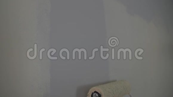 用白色油漆的油漆滚筒油漆裸露的墙壁视频的预览图