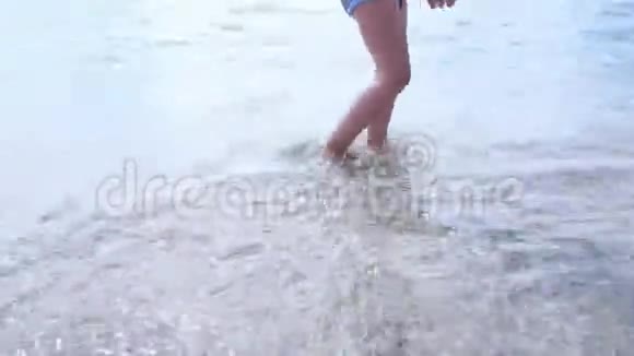 快乐的赤脚孩子在海滩散步中玩得开心女孩在水池边沿着海浪奔跑溅起水花夏季视频的预览图