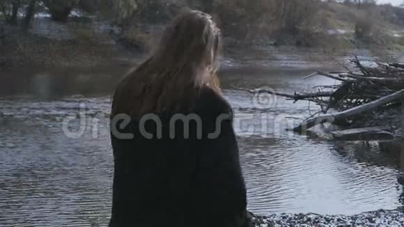 下雪时河边的黑发女人视频的预览图