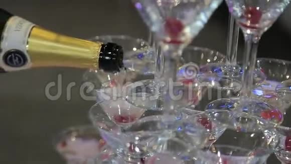 从一个瓶子里倒两杯香槟两个香槟杯上的散焦把香槟倒入精美的酒杯视频的预览图