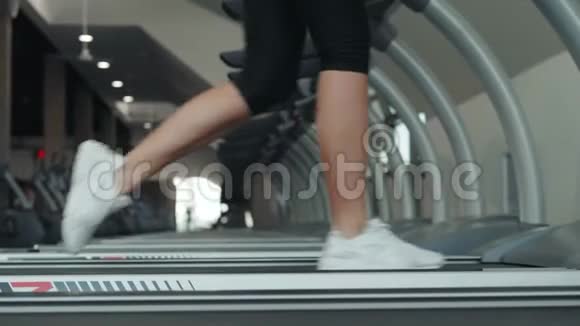 一个女人在跑步机上跑步的特写白色运动鞋运动女运动员训练快运动员视频的预览图