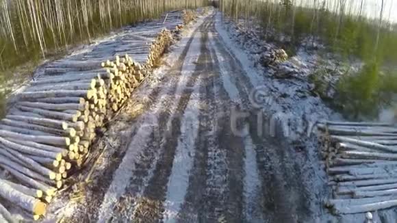 在冬天的时候乡村道路和砍伐的树木冬季景观道路柴禾空中景观视频的预览图