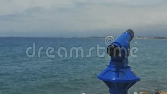 年轻漂亮的女人用慢镜头看着大海的望远镜视频的预览图