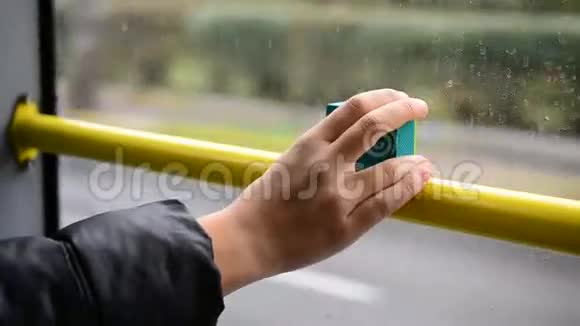 少年手拿着一个动作相机靠近车窗的公共汽车视频的预览图
