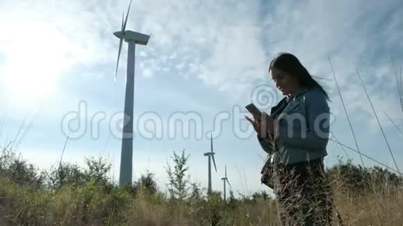 在风车农场使用智能手机的女孩视频的预览图
