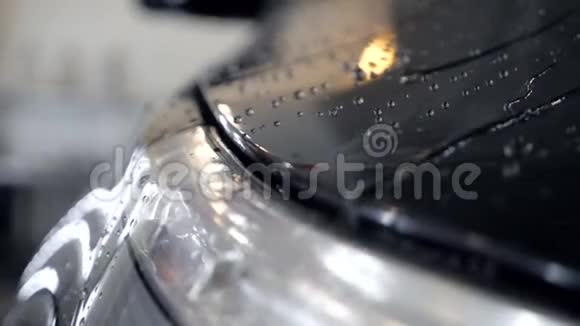 洗车慢动作后水滴在黑色汽车上流动视频的预览图