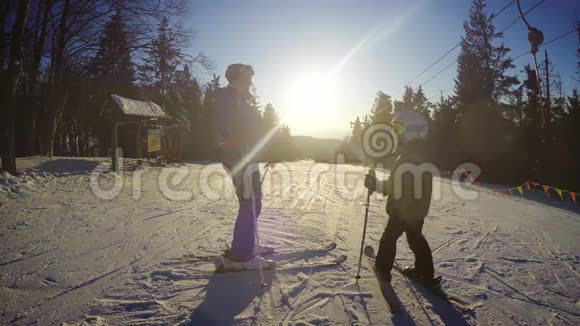 4K寒假片段儿子和母亲在晴天滑雪视频的预览图