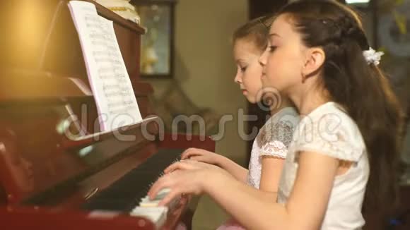 美丽的小女孩一起弹钢琴视频的预览图