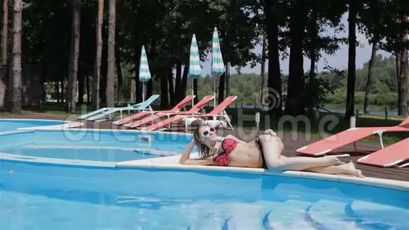 女人躺在游泳池的对面视频的预览图