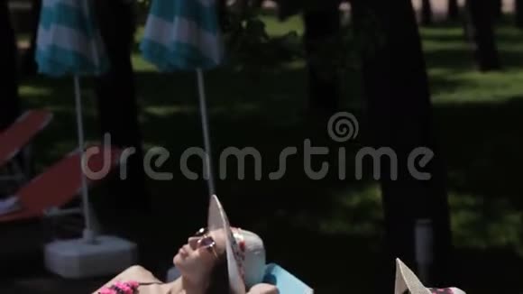 两个女人躺在游泳池附近的左臀部视频的预览图