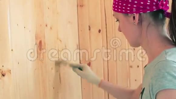 年轻女子画木墙视频的预览图