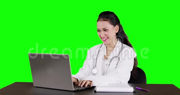 漂亮的女医生用笔记本电脑工作视频的预览图