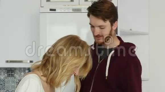 幸福的微笑情侣在厨房里亲吻拥抱视频的预览图