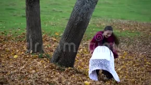 妈妈和她的小女儿在秋天的森林里玩得很开心他们跳起来把树叶扔到空中他们是视频的预览图